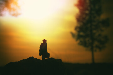 Obraz premium Surreal image of mysterious man walking alone in field during sunset