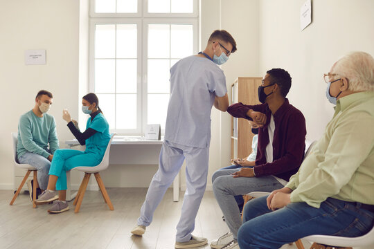 Young doctor elbow greets an african american patient during a coronavirus pandemic.