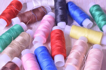 a lot of spools with multi-colored threads on a light background