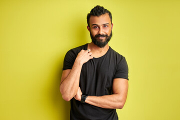 shy arabic man looks at camera, diligent bearded guy isolated on green background