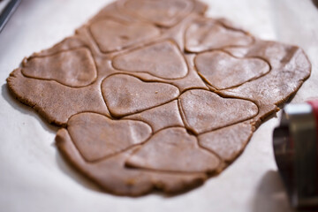 Raw rolled gingerbread dough, cutting festive shaped cookies