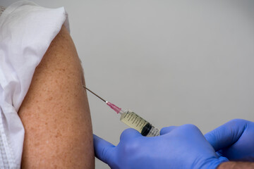 Manos del médico inyectando la vacuna.