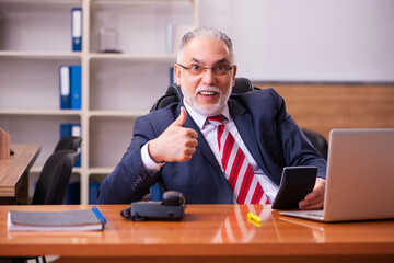 Old male employee sitting in the office