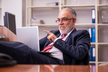 Old male employee sitting in the office