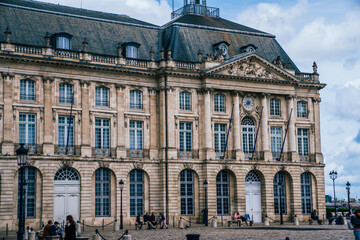 Old historical palace on crowded square under cloudy sky