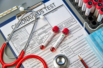 Two test tubes with blood samples for the COVID-19 test on the coronavirus test form. Blood test...