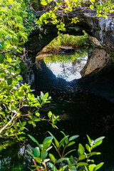 Cenote unter einem Felsbogen