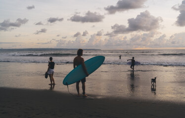 Fototapeta na wymiar Anonymous surfer standing on shore of beach