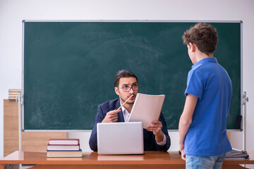 Young male teacher and schoolboy in the classroom