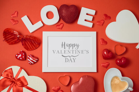 Valentine's day holiday concept with photo frame, gift box and heart shape on red background