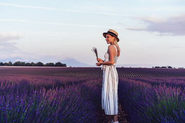Calm female traveler with lavender flowers in lavender field
