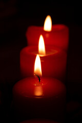Flame red candles isolated on black background. Close up.
