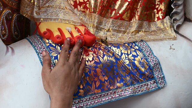 Vijayadashami, married Bengali Hindu woman applying sindur, vermilion, on the feet of Goddess Durga. Durga puja festival traditional ritual, performed before immersion of the Goddess.