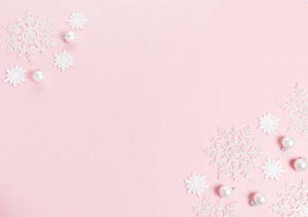 White Christmas holiday composition. Festive creative white pattern, xmas decor holiday ball with snowflakes on pink background.