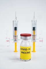 A single bottle vial of Covid-19 coronavirus vaccine and two syringes. A covid-19 coronavirus vaccination concept. It use for prevention and immunization. Vertical vaccine concept on white background.