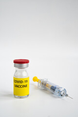 A single bottle vial of Covid-19 coronavirus vaccine and syringe. A covid-19 coronavirus vaccination concept. It use for prevention and immunization. Vertical vaccine concept on white background.