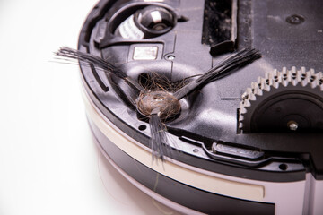 Hair on the brushes of a robot vacuum cleaner close-up.