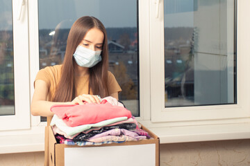 Charity and assistance to the poor, orphans, and the needy. Volunteer girl puts clothes in a...