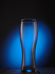 Empty beer glass on blue background
