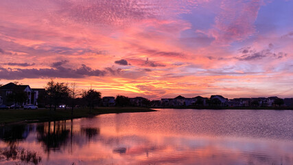 Obraz premium Beautiful pink, orange and blue sunset reflecting on a lake