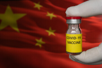 Vaccine, syringes and Chinese flag. Microbiological research in China. Development of antiviral drugs in the Republic of China. Hand is holding a bottle covid-19 vaccine. Sinovac new china vaccine.