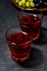 two glasses of red young wine on a dark background, vertical closeup