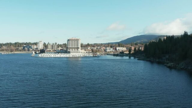 Aerial drone flying toward Coeur d'Alene beside Tubbs Hill on sunny day