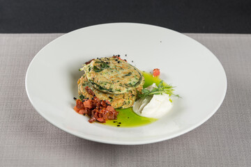 Zucchini pancakes served with sun-dried tomatoes and cream cheese