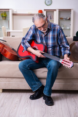 Senior male repairman repairing musical instruments at home