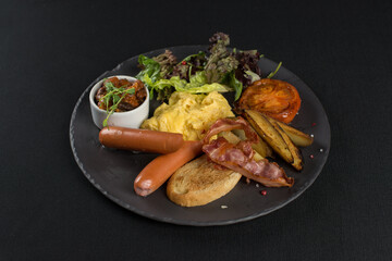 Traditional English breakfast. Sausage, beans, eggs, bread and salad