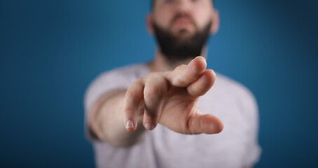 blue background young man finger pointing touch