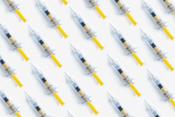 Creative Covid-19 vaccine concept, flat lay. Many syringes on white background. Creative medicinal pattern from syringes of white background. Flat lay, top view, copy space.