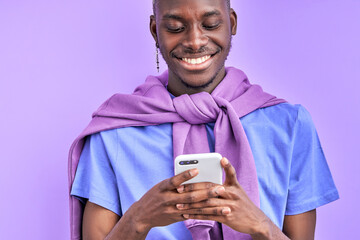 african guy looking at smartphone, wathcing funny video or talking with someone. isolated on purple...