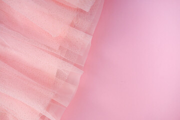 fragment of a tulle skirt on a pink background