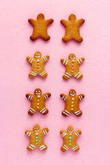 Smiling Christmas gingerbread men with happy faces on pink background