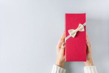 Fototapeta na wymiar Valentine gift or christmas . - Beauty Woman hands holding red gift box with white bow.