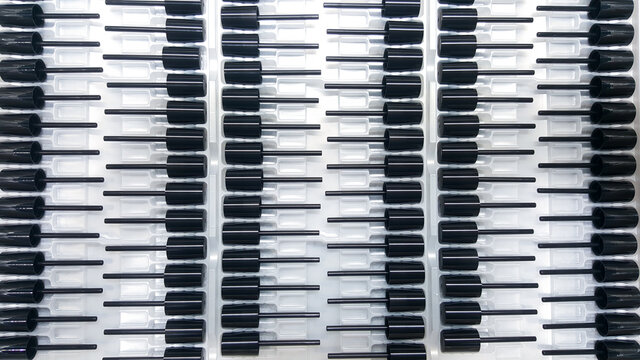 Photos of black lipstick caps, parts of cosmetic plastic products, from the industrial plastic production department.
