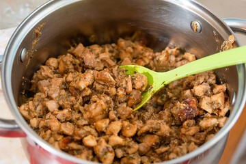 Fried chopped meat for shawarma lies in a saucepan.