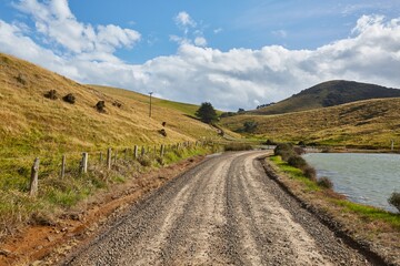 Fototapeta na wymiar Driving on a dirt road in the hills in New Zealand