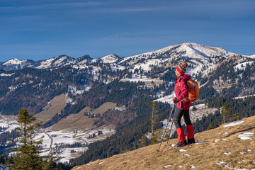Obraz premium nice and active senior woman snowshoeing in deep powder snow in the Allgau alps, Bavaria, Germany