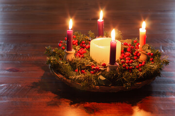 Advent wreath, Christmas candles lit on wood table