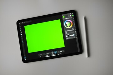 Green background for digital drawing on tablet. Remote creative freelance work. 