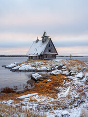 Minimalist snowy winter landscape with authentic house on the shore in the Russian village Rabocheostrovsk