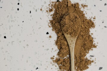 Guarana powder in wooden spoon on white marble background.Super food. Useful product. Healthy eating concept. Natural energetic. Portion of Guarana Powder. top view, copy space.