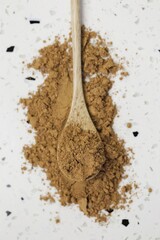 Guarana powder in wooden spoon on white marble background.Super food. Useful product. Healthy eating concept. Natural energetic. Portion of Guarana Powder. top view