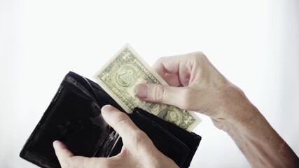 Senior Hand Takes One Dollar From Old Wallet On White Background. Poverty And Financial Problems Concept.