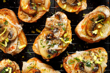 Mushroom and cheese  crostini sprinkled with spices and chopped fresh herbs top view. Delicious...
