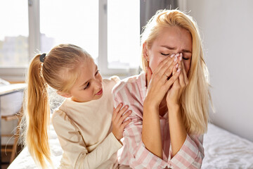 sympathetic kid girl calm down her crying mother, try to help, ask what happened, they sit on bed...