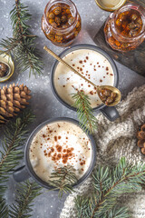 Obraz na płótnie Canvas Coffee latte with pine needles and pine cone jam, trendy organic winter coffee hot drink with whipped cream. Homemade Pine Juniper Latte, on grey concrete background flatlay