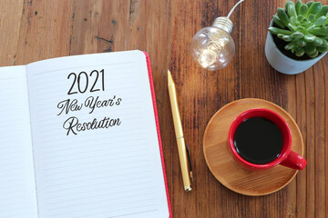 Business concept of top view 2021 resolution with notebook, cup of coffee over wooden desk